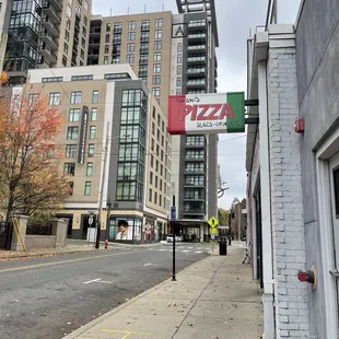 a pizza sign on a sidewalk