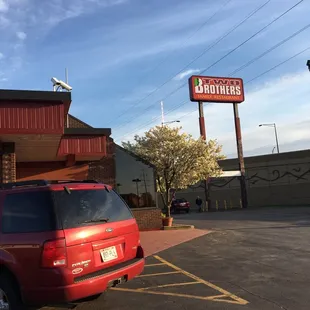 a red car parked in front of the restaurant