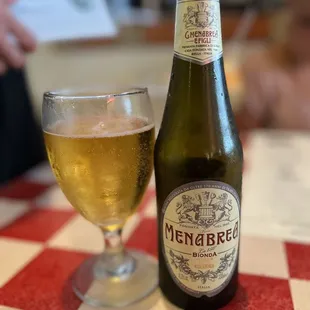 a bottle of pizzeria and a glass of beer