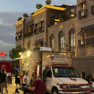 a group of people standing in front of a food truck