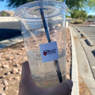 a hand holding a cup with a drink in it