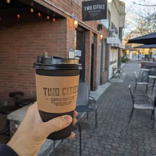 a hand holding a cup of coffee