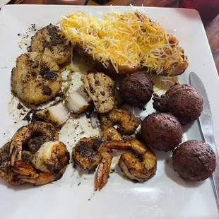 Blackened shrimp and scallops with hush puppies and a twice baked potatoe. Delicious!