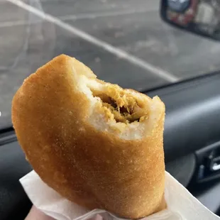 a person holding a doughnut in their hand