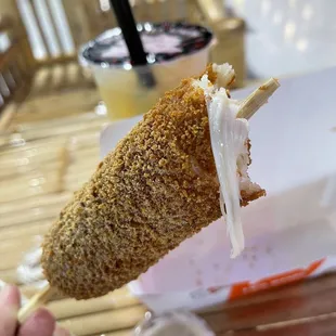 a hand holding a corn dog