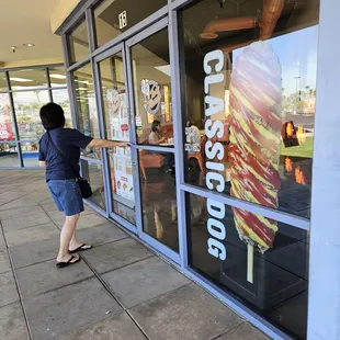 a woman standing in front of a store window