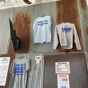 a t - shirt and a t - shirt hanging on a corrugated wall