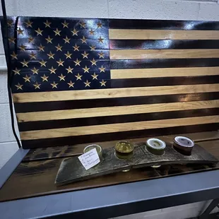 a wooden american flag and two cups of cid