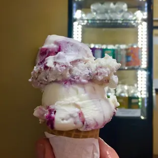 a hand holding a cone of ice cream