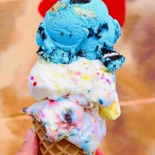 a hand holding a cone of ice cream