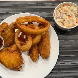 Half of my 4 piece mixed spicy chicken order with onion rings and cole slaw.