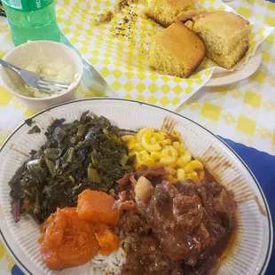 Oxtails, greens, rice and gravy, Mac n cheese, candied yams, cornbread, potato salad