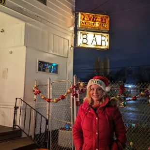 a woman standing in front of a bar