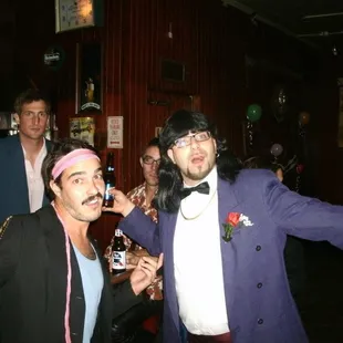 a man in a purple suit and a man in a pink tuxedo