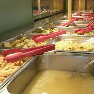 a line of food being served at a buffet