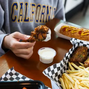 a woman eating a hot dog and fries