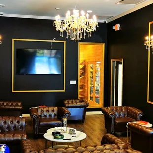 a living room with leather couches and chandeliers