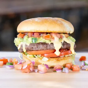 a hamburger with lettuce, tomato, and onion