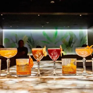 a variety of cocktails on a bar