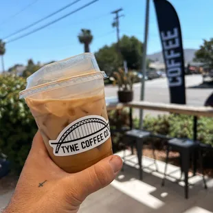 a hand holding a cup of coffee