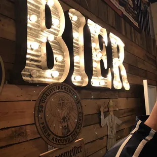 a man sitting in front of a beer sign
