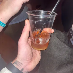 a person holding a drink in their hand