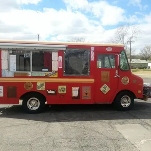 a red food truck parked in a parking lot