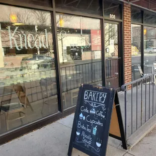a chalkboard sign on the sidewalk