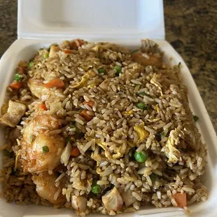 a takeout container with rice and chicken