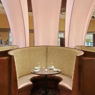 a corner booth with a table and chairs