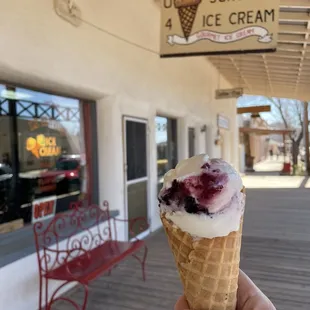 a hand holding an ice cream cone