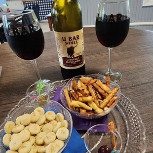 a glass of red wine, a plate of cookies, and a bottle of wine