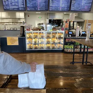 a person handing a bagel to a customer