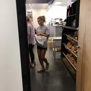 a woman walking through a deli shop