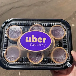 a hand holding a container of cookies