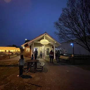 a group of people standing outside a building at night