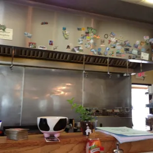 a kitchen counter with a bunch of magnets on the wall
