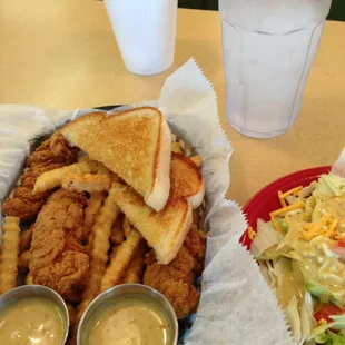a plate of fried chicken, fries, salad and a drink