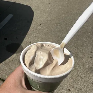 a hand holding a cup of ice cream