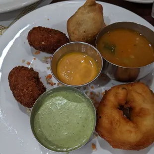 a plate of food with dipping sauces