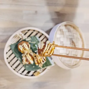 a bowl of food with chopsticks