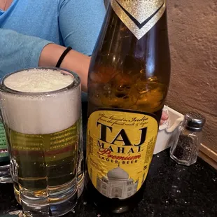 a woman sitting at a table with a beer