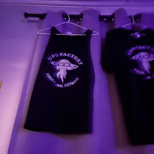 two t - shirts hanging on a wall