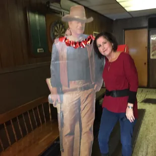 a woman standing next to a cardboard man