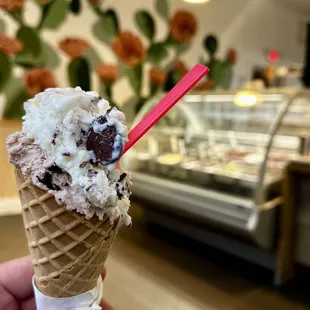 a hand holding a cone of ice cream