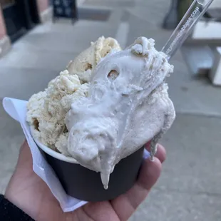 a hand holding a cup of ice cream