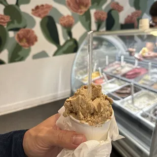 a person holding a cup of ice cream