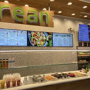a restaurant counter with menus on the wall