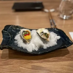 three oysters on a plate with sea salt