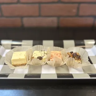 a variety of cheesecakes on a checkered plate